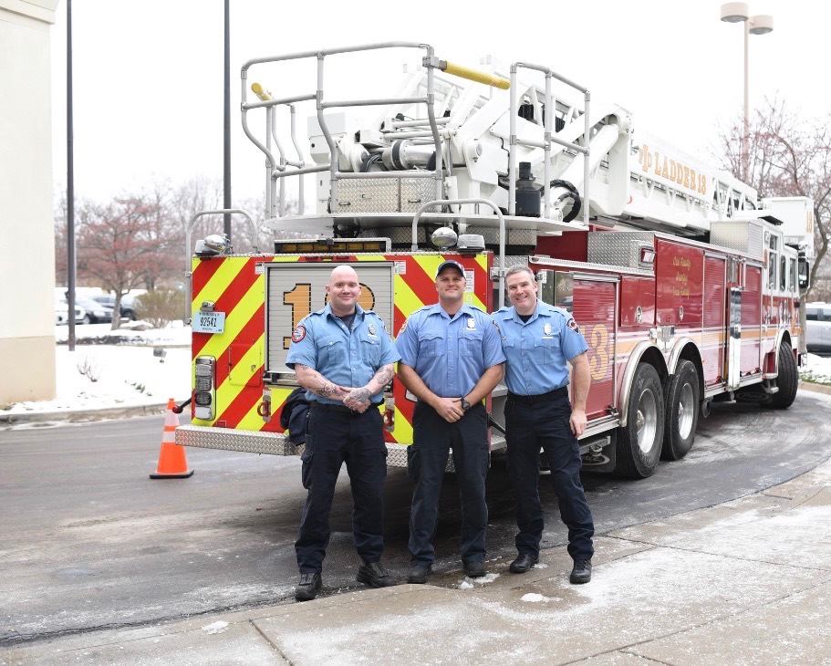 Firefighters standing in front of a fire truck